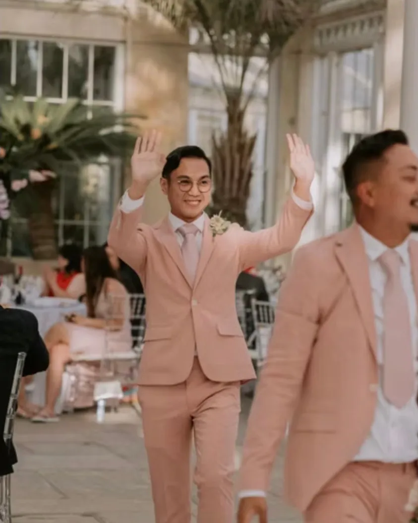 Dante Domingo crossing the floor during a reception, hands raised