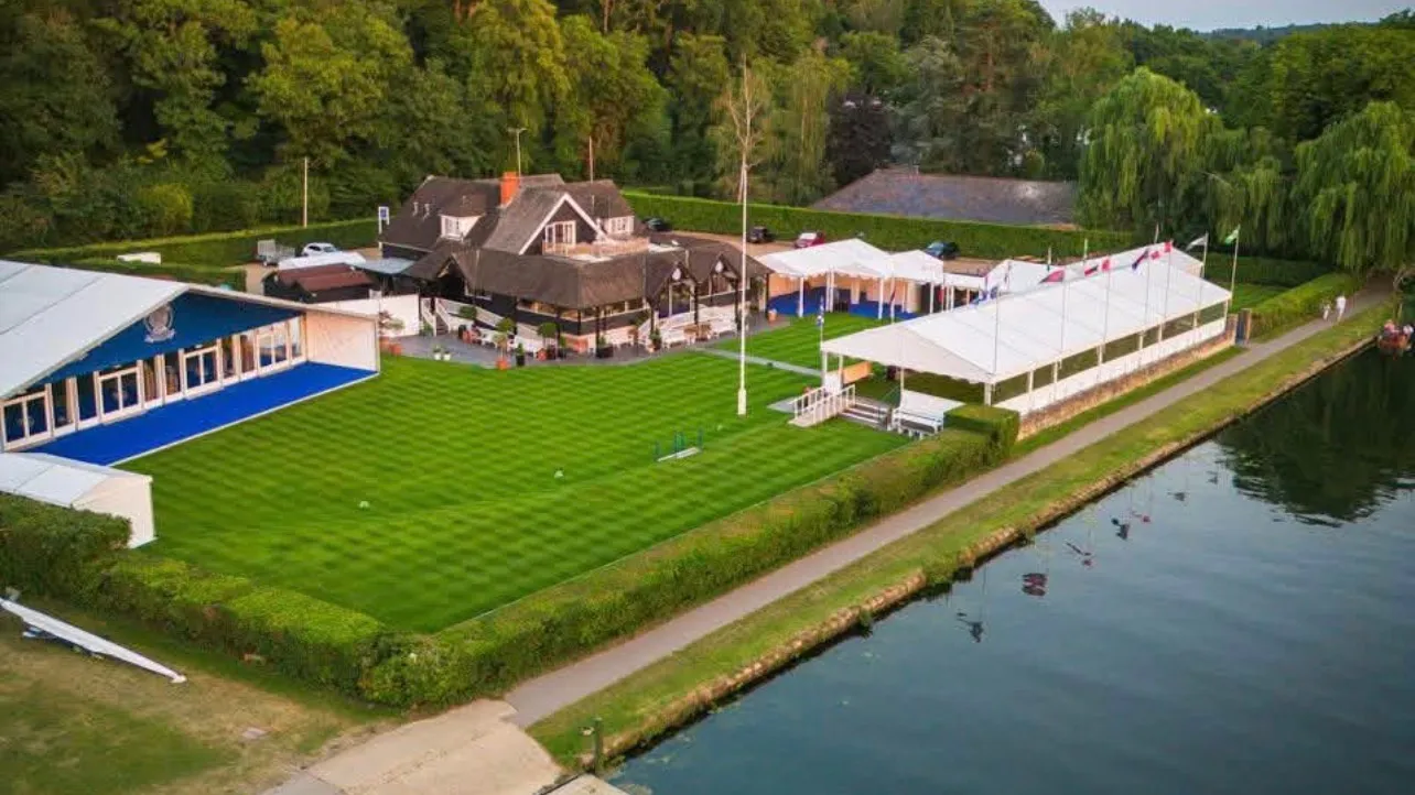 The clubhouse, lawn and riverside marquees from the air, with the towpath and the Thames running past